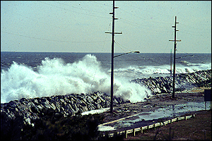 Photo: Waves crashing over seawall.